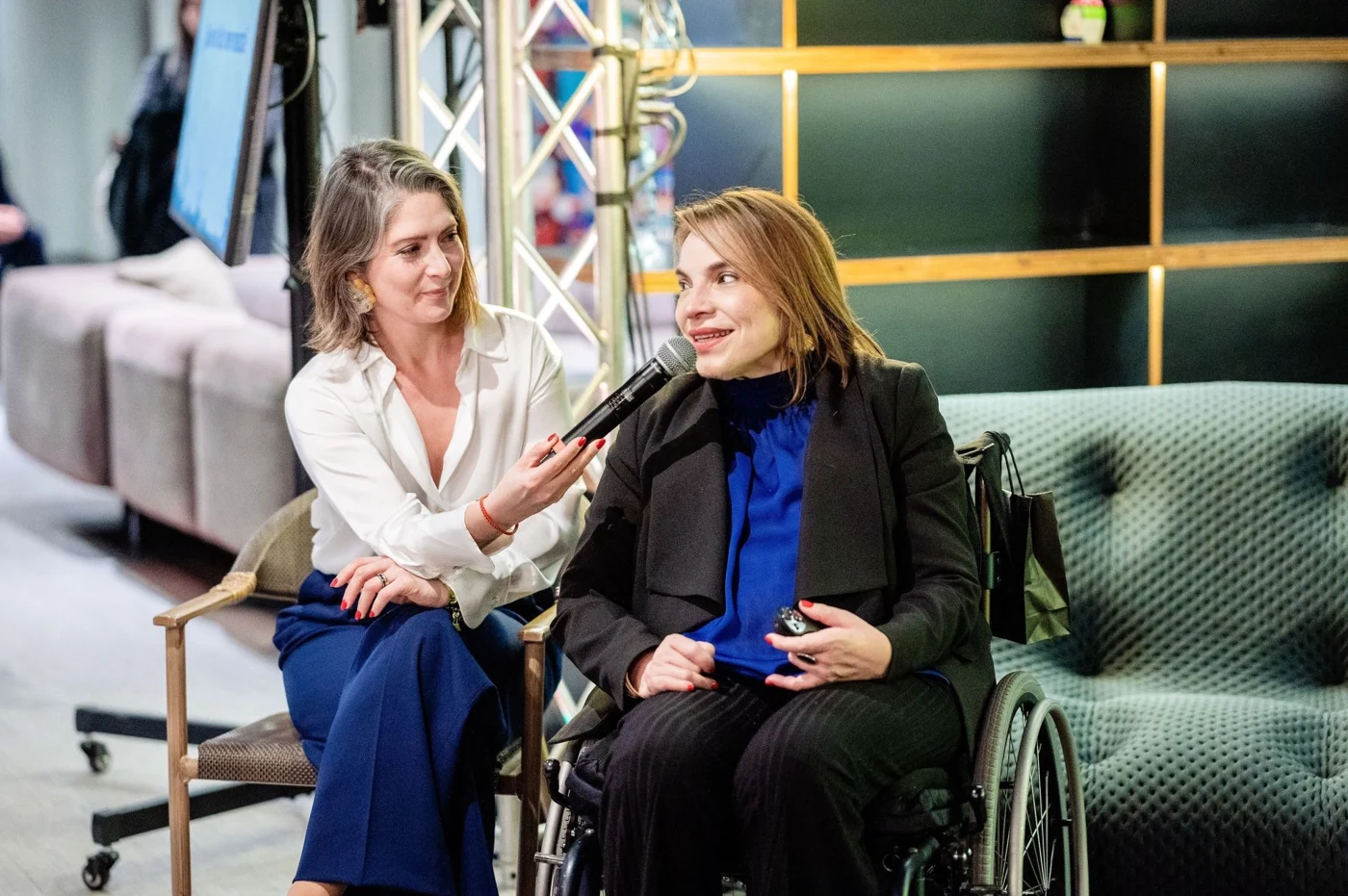 Carolina García Berguecio speaking into a microphone at the Revista Nosotras event.